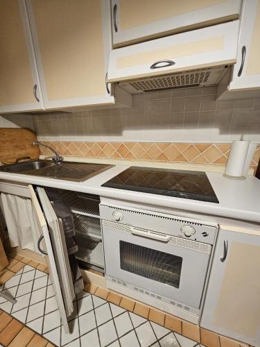a white kitchen with a stove and a sink at Sestriere Center Flat in Sestriere