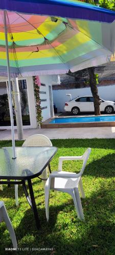 a table and chairs under a colorful umbrella at Casa Guacamayas in Tlatenchu
