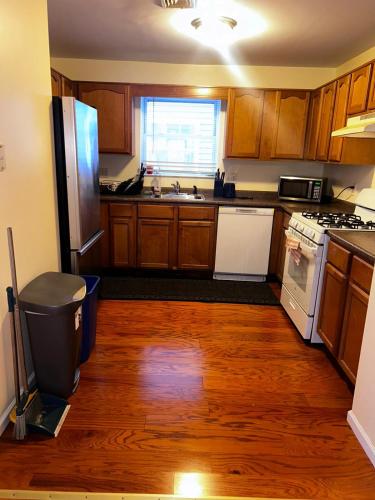 a kitchen with wooden floors and a refrigerator and a sink at 3-Bedroom Apt 5 miles AirPort in Newark