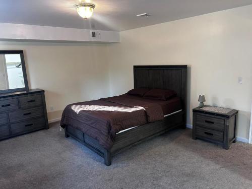 a bedroom with a bed and two dressers and a mirror at 3-Bedroom Apt 5 miles AirPort in Newark