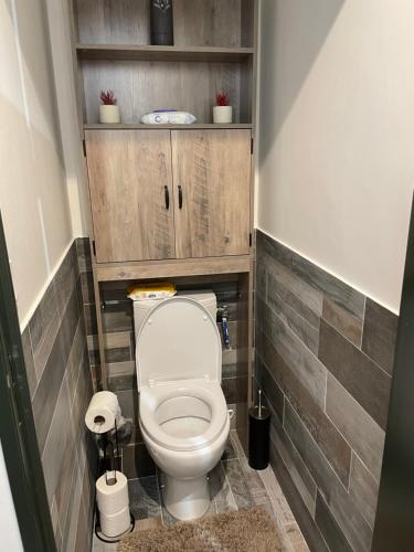 La petite salle de bains est pourvue de toilettes et de placards en bois. dans l'établissement Le Marina, à Sanary-sur-Mer