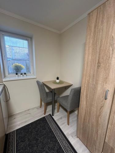 a room with a table and two chairs and a window at Sobe Tanja in Subotica