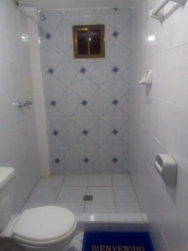 Un baño blanco con inodoro y ducha. en Willka Uta, en Comunidad Challapampa