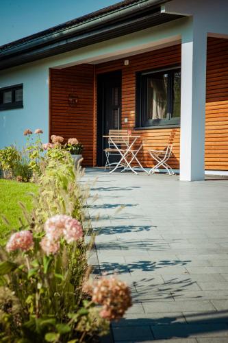 a porch of a house with chairs and flowers at Ferienhaus Eifeltoni in Nettersheim
