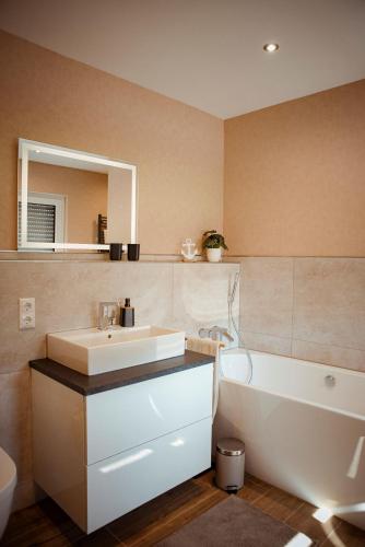 a bathroom with a sink and a tub and a mirror at Ferienhaus Eifeltoni in Nettersheim