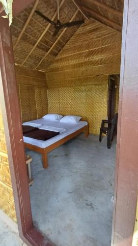 a bedroom with a bed in a straw hut at River Bay Hampi in Hampi
