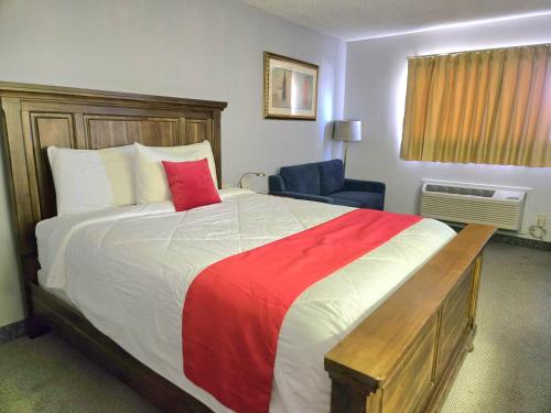 OzarkにあるAmerican Inn Ozarkの赤い毛布が掛けられた大きなベッドのある寝室