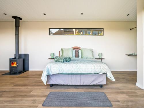 a bedroom with a bed and a fireplace at Cozy Retreat in Knysna