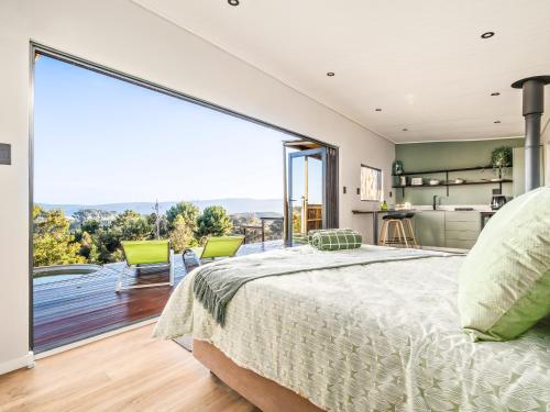 a bedroom with a bed and a large window at Cozy Retreat in Knysna