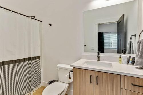 a bathroom with a toilet and a sink and a mirror at 3 Mins to DT Lux Townhome 2 Car Garage King Bed in Salt Lake City