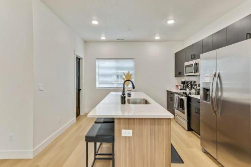 a kitchen with a sink and a stainless steel refrigerator at 3 Mins to DT Lux Townhome 2 Car Garage King Bed in Salt Lake City
