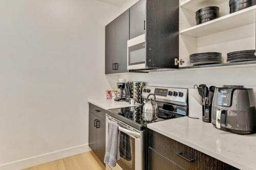a kitchen with stainless steel appliances and wooden cabinets at 3 Mins to DT Lux Townhome 2 Car Garage King Bed in Salt Lake City