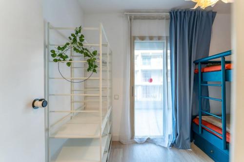 Una habitación con una planta en un estante junto a una puerta. en Salou Luxury Stay Beach Pool WiFi AC, en Salou