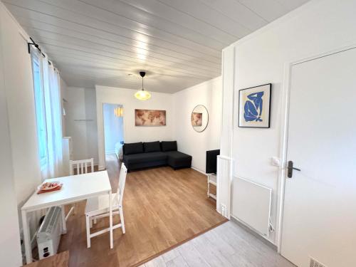 un salon avec un canapé noir et une table dans l'établissement One Bedroom Apt - Subway 5 min -Quiet Neighborhood, à Montrouge