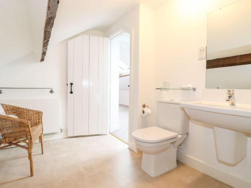 a white bathroom with a toilet and a sink at Middletown in Keswick