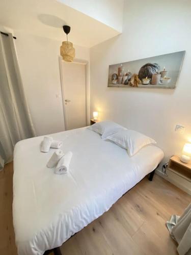 a bedroom with a white bed with two towels on it at Nouveau-L'Alsakrat-au coeur de Munster in Munster