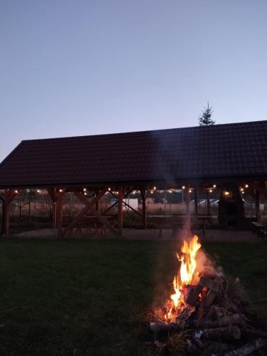 a fire in the grass in front of a building at Checz Gościnna- pokoje,sauna,jacuzzi, sala konferencyjna in Grzybno