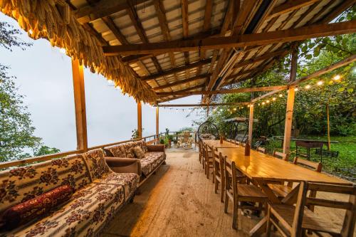 a large wooden table with couches and a wooden tableablish at Guest House Mokvare in Gundauri