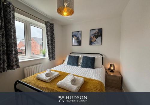 a bedroom with a bed with two towels on it at 3 Bedroom Modern Property with Parking in Shrewsbury