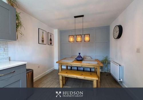 a kitchen with a table and a clock on the wall at 3 Bedroom Modern Property with Parking in Shrewsbury