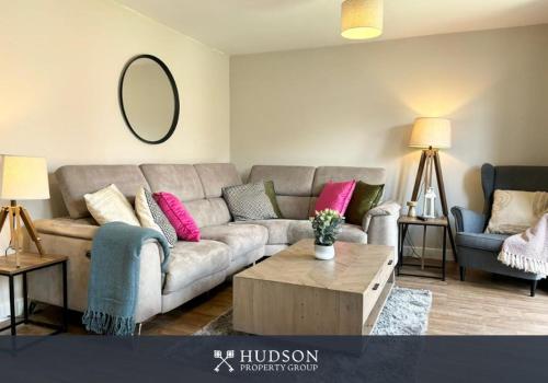 a living room with a gray couch and pink pillows at 3 Bedroom Modern Property with Parking in Shrewsbury
