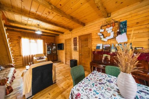 a dining room with a table and chairs in a cabin at Guest House Mokvare in Gundauri