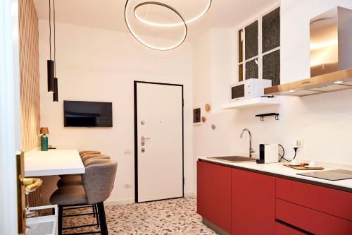 a kitchen with red cabinets and a white counter at MILANO URBAN FLATS Suite Sanzio 20 - Vicino a Duomo, Stadio e Fiera in Milan