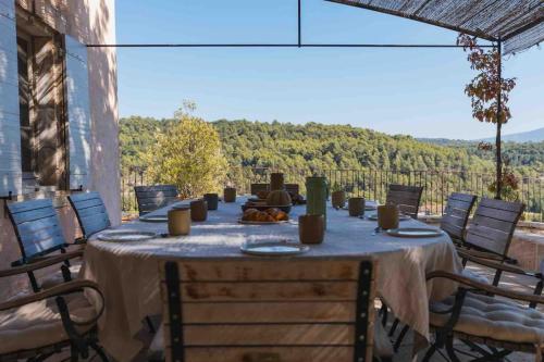 - une table sur une terrasse avec des chaises et une vue dans l'établissement Bastide la Belle Étoile, à Apt