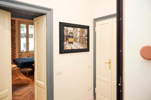 a door with a picture of a train on the wall at MILANO URBAN FLATS Suite Sanzio 20 - Vicino a Duomo, Stadio e Fiera in Milan