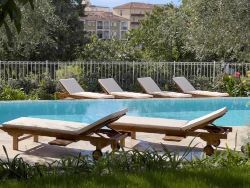 Una fila de tumbonas junto a una piscina. en Villa La Rodina, en Diano Marina