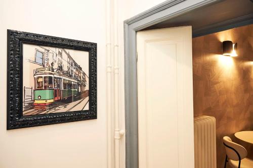 a framed picture of a tram on the wall at MILANO URBAN FLATS Suite Sanzio 20 - Vicino a Duomo, Stadio e Fiera in Milan
