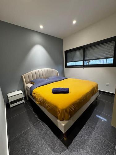 une chambre avec un lit avec une couverture jaune dans l'établissement Grande Villa 16 personnes, à Aulnat