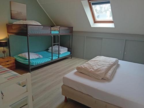 une chambre avec deux lits superposés et une fenêtre dans l'établissement Cap Mer - Maison 500m plage du Palandrin, à Pénestin