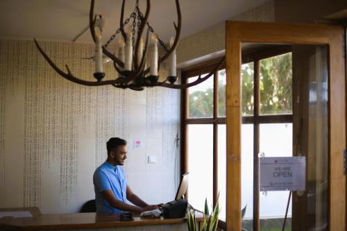 a man standing at a counter in a room at Lavinia Blue Hotel in Mount Lavinia