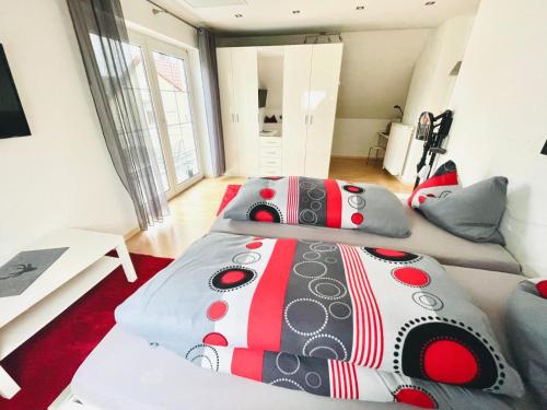 two beds in a room with a red carpet at Haus Dragl Apartment in Friedberg