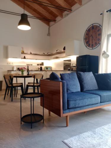 a living room with a blue couch and a kitchen at Vivai Natura Country Loft in Basiglio