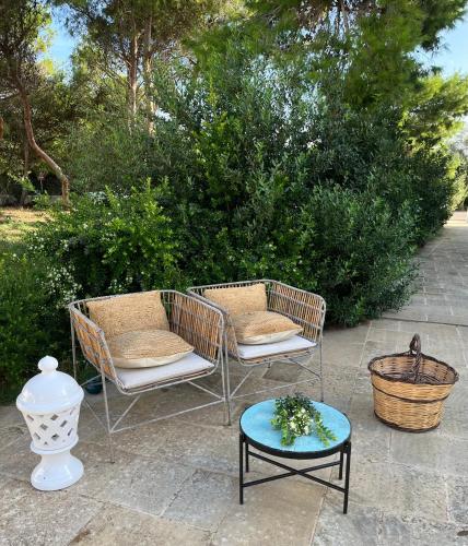 two chairs and a table on a patio at Acqua di Mare in Torre Specchia Ruggeri