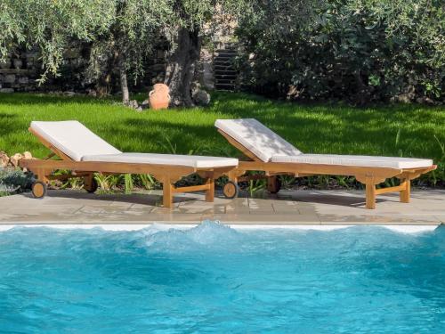 two lounge chairs next to a swimming pool at Villa Mimosa Diano Marina: exclusive use villa, garden, barbecue, 3 bedrooms and 3 bathrooms in Diano Marina