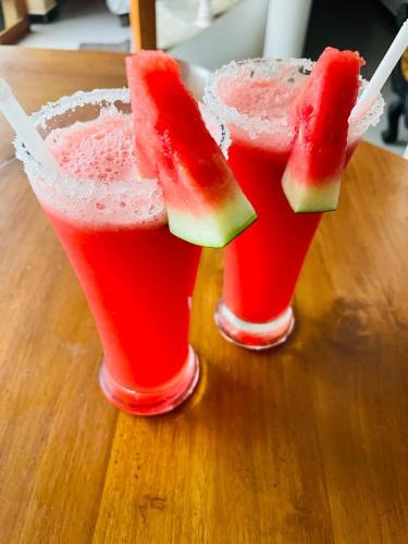two glasses of watermelon margaritas on a wooden table at Lavinia Blue Hotel in Mount Lavinia