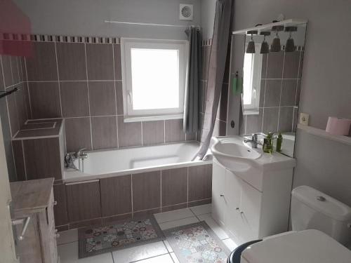 une salle de bain avec une baignoire, un lavabo et des toilettes dans l'établissement Maison Strasbourg 7 chambres, à Ostwald