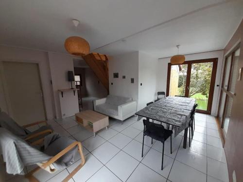 un salon avec une table et un canapé dans l'établissement Maison Strasbourg 7 chambres, à Ostwald