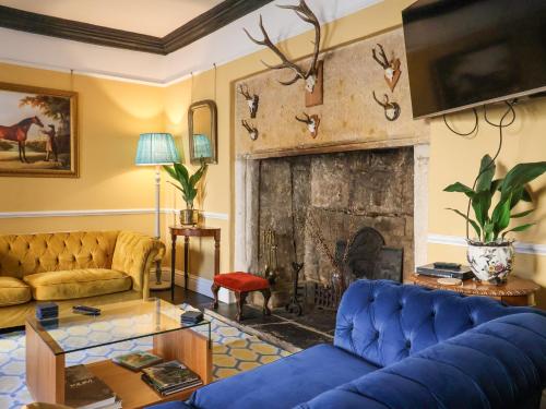 a living room with a blue couch and a fireplace at Old Monmouth in Lyme Regis