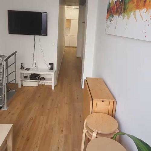 un salon avec une table et une télévision au mur dans l'établissement Charm in Heart of Paris Vaugirard, à Paris