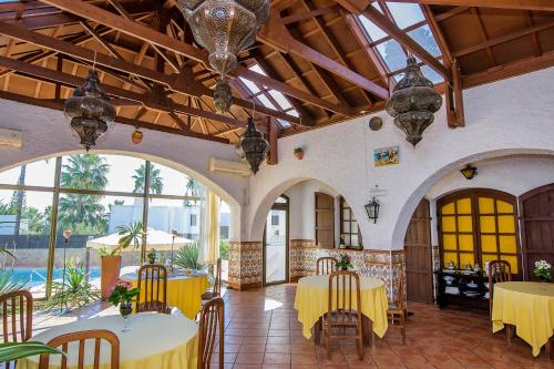 a large room with tables and chairs and windows at Family Agua Amarga in Agua Amarga