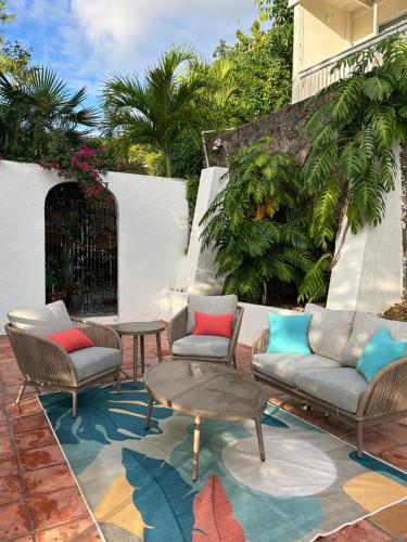 a patio with chairs and tables on a rug at The Mary Anne Boutique Hotel USVI in Charlotte Amalie