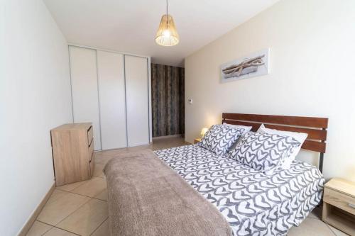 ein Schlafzimmer mit einem großen Bett mit einem hölzernen Kopfteil in der Unterkunft Aillan Hervé Villa piscine chauffée et son spa in Saint-Maurice-sur-Eygues