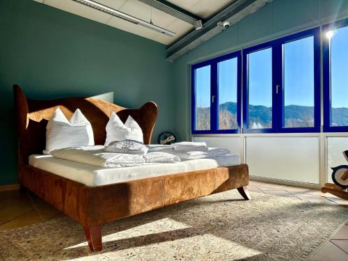 un grande letto in una stanza con finestre di muchhome LUXURY APARTMENTS - MuchLoft - Vintage Loft in Bad Tölz mit Freizeitlounge a Bad Tölz