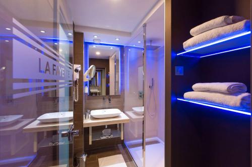 a bathroom with a sink and a mirror and towels at Best Western Plus La Fayette Hotel et SPA in Épinal