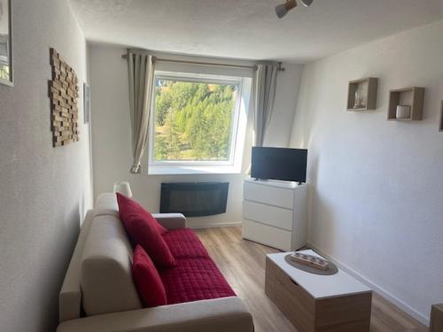 un salon avec un canapé et une fenêtre dans l'établissement Studio La Foux d'Allos les Etoiles, à Allos