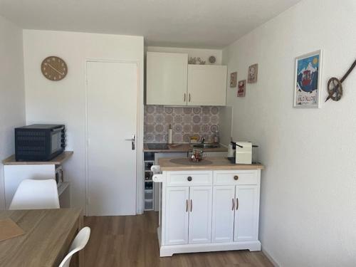 une cuisine avec des armoires blanches et un comptoir dans l'établissement Studio La Foux d'Allos les Etoiles, à Allos